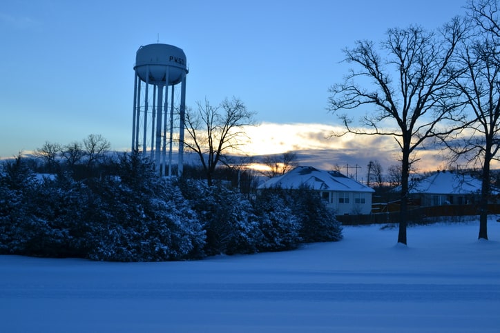 Water tower overlooking a snowy neighborhood