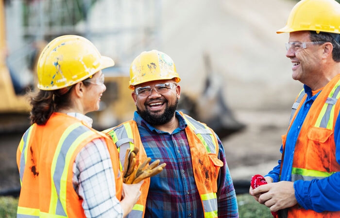 Construction workers in hi-vis safety gear talking to each other