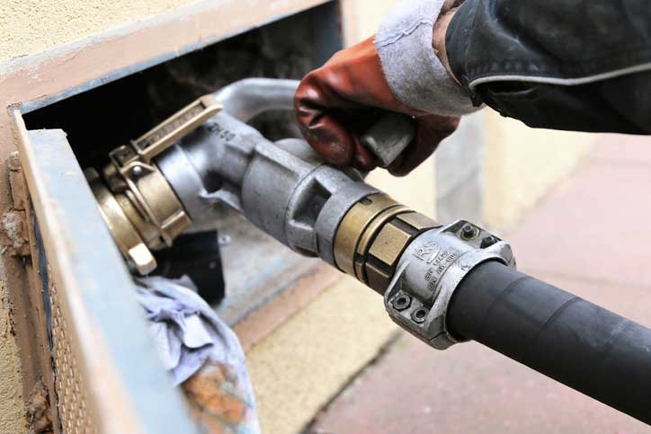 Worker operating a fuel hose. mobile view