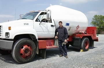 Driver standing beside an industrial vehicle - courtesy of Propane Education and Research Council mobile view