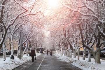 Winter scene with pedestrians walking along a snowy street
