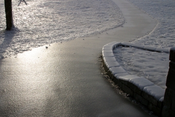 Slippery sidewalk covered in black ice