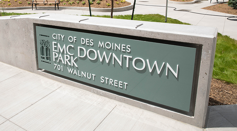 Light green sign with tree on left and City of Des Moines, EMC Downtown Park, 701 Walnut Street text