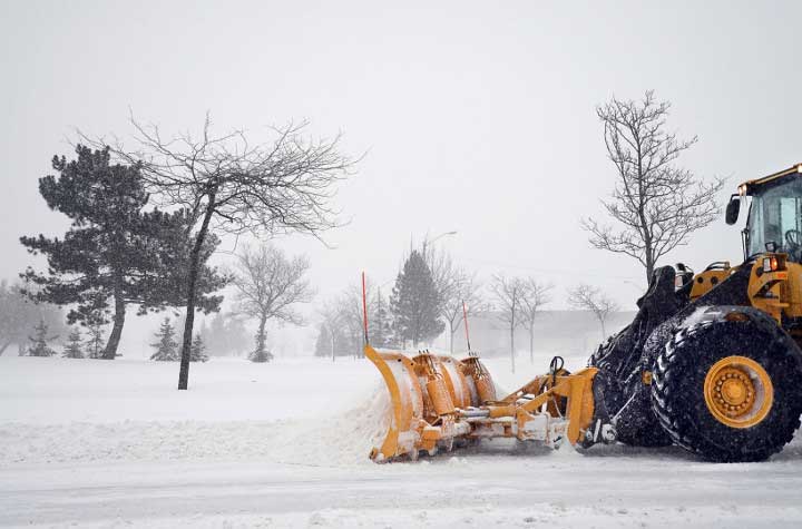 Large snowplow clearing a road of snow.