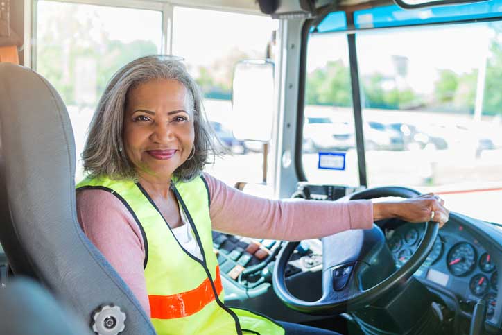 Woman school bus driver driving a bus mobile view