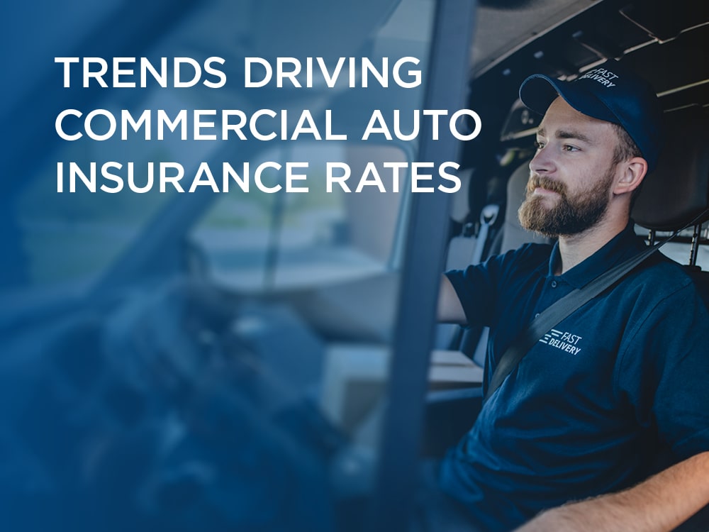 Man driving a truck with text over photo that says trends driving commercial auto insurance rates mobile view