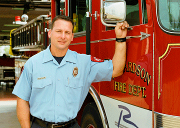 Firefighter holding the handle of a fire truck