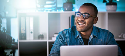 Man at a laptop smiling.